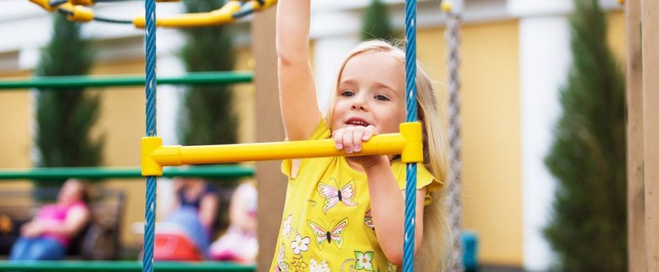 Young girl playing on playground equipment